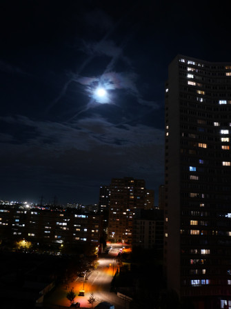 Gammes sur l'exposition : la pleine lune vue de mon salon, avec les fenêtres des tours allumées pour certaines et l'éclairage urbain rose orangé au sol.